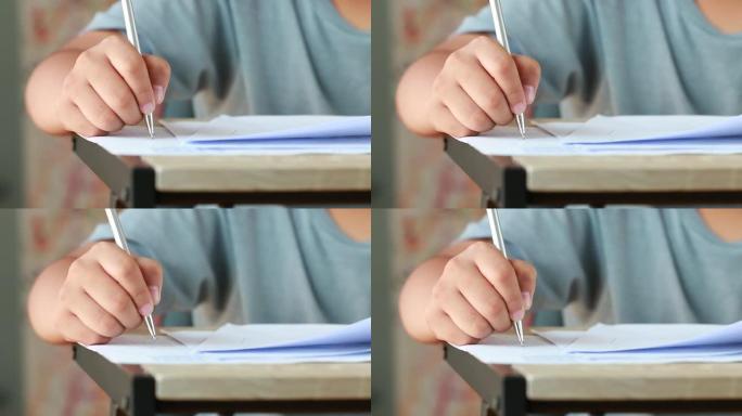 大学或高中的教育考试概念: 用手拿着铅笔在答题纸上测试考试，在校园教室填写考试文件。知识学习理念