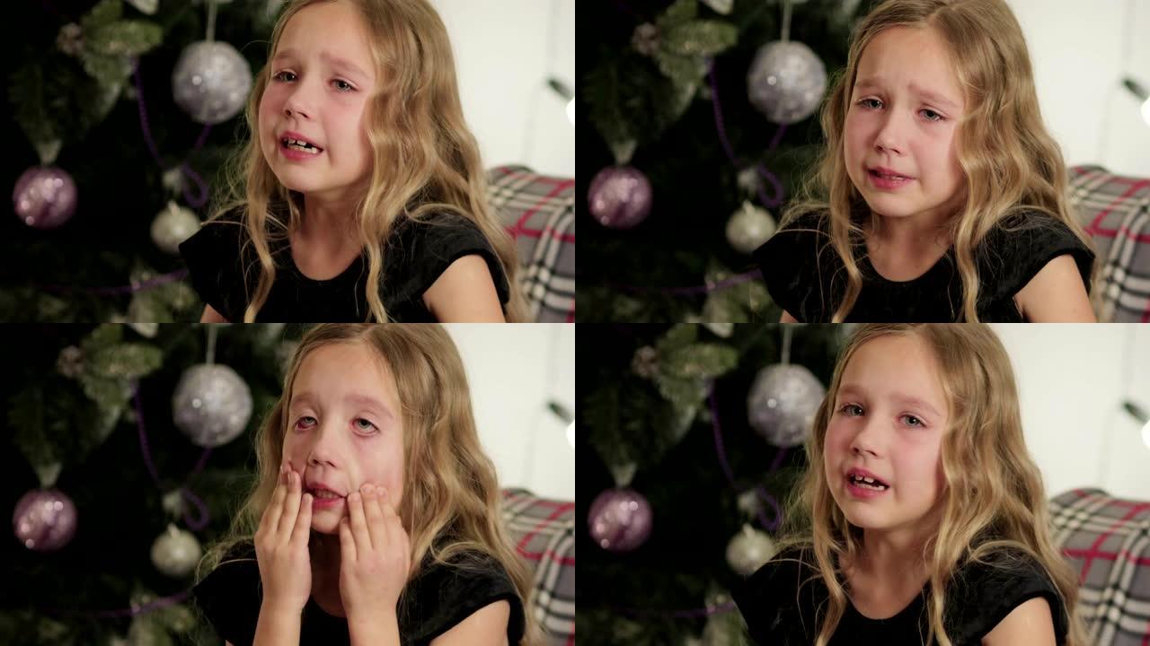 美丽，小女孩坐在圣诞树的背景中哭泣