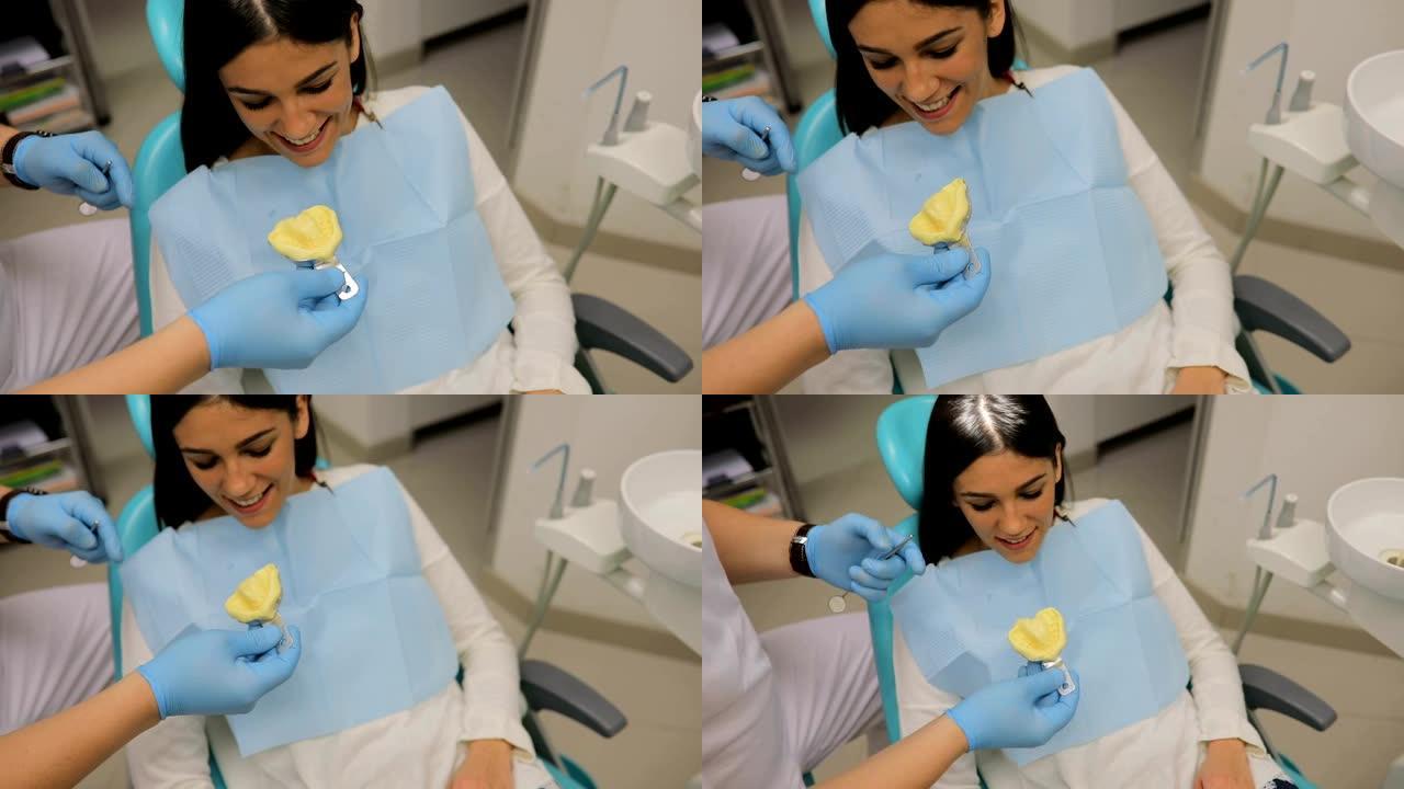 牙医向患者展示牙齿模具上的牙齿问题