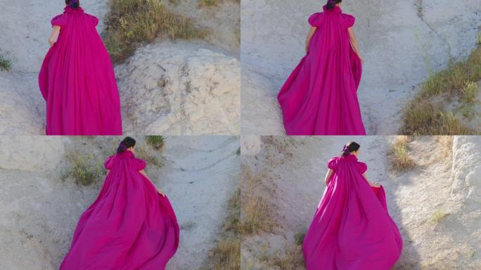 年轻的高个子女孩模特穿着紫色长裙在山上奔跑