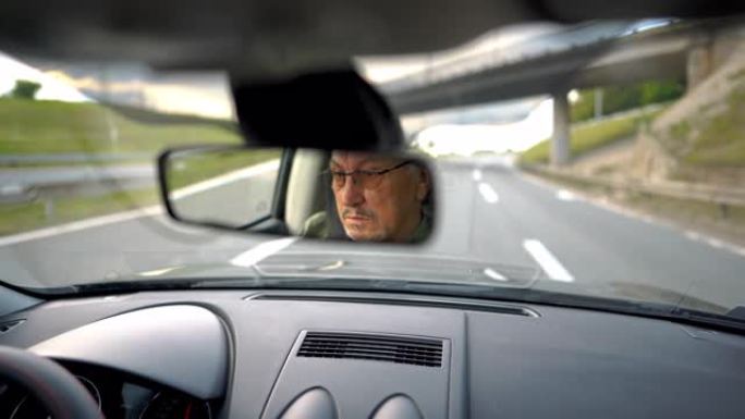 经验丰富的老人戴着眼镜在高速公路上开车