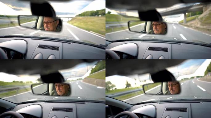 经验丰富的老人戴着眼镜在高速公路上开车