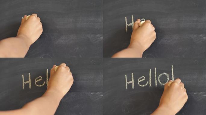 女人的手的特写镜头，用一大块黄色粉笔在尘土飞扬的用过的黑板或黑板上用感叹号写下 “你好”。