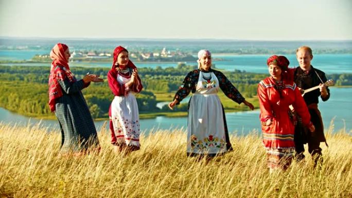 穿着传统俄罗斯服装的年轻合奏在球场上跳舞。