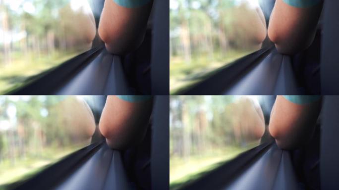 通过窗户观看公共汽车，人的肘部在窗户旁边的右侧。巴士旅行概念。乘公共汽车旅行时透过窗户模糊的视线。
