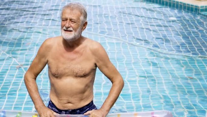 资深老人站在游泳池里。水上运动。高级活动