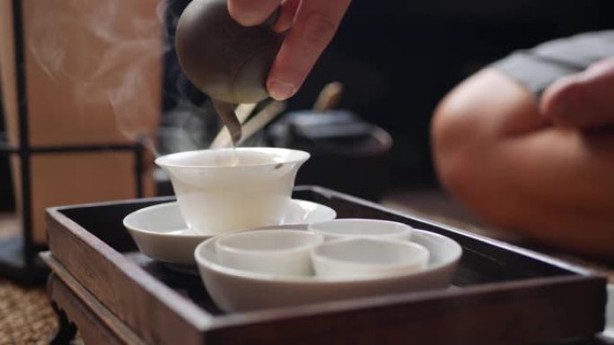 中国传统功夫或功夫茶道。茶师将绿茶倒入盖湾或中。中国传统文化的元素。特写。4k