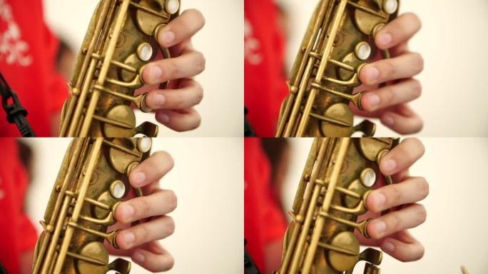 一个男人的手指在一个音乐团体中按下萨克斯管键