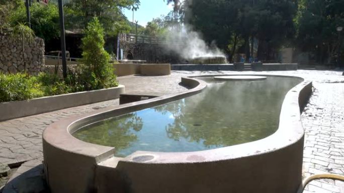泰国拉农Raksa Warin公园的著名温泉井的脚浸池和蒸汽上升。