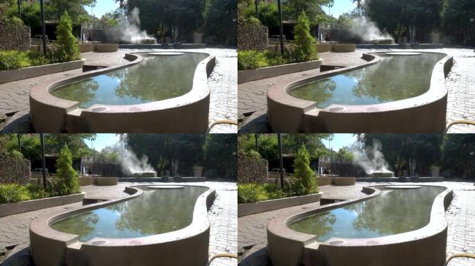 泰国拉农Raksa Warin公园的著名温泉井的脚浸池和蒸汽上升。