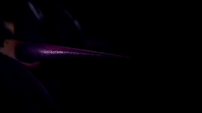 黑暗工作室里长长的紫色尖尖指甲