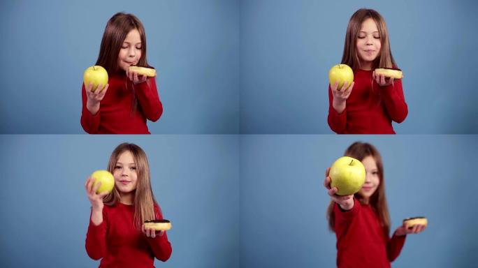 可爱的小女孩选择一个覆盖着五颜六色的巧克力甜甜圈和一个绿色的新鲜苹果，决定吃一个苹果。健康的生活方式