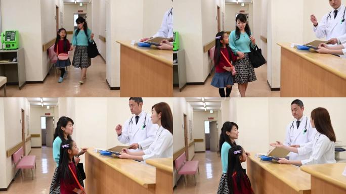 日本妇女和女儿在医院病房与医生交谈