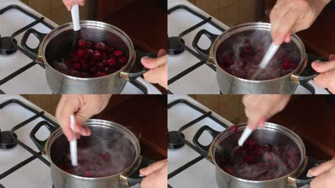 一个人在平底锅里混合了一勺冷冻小红莓。为棉花糖准备土豆泥。