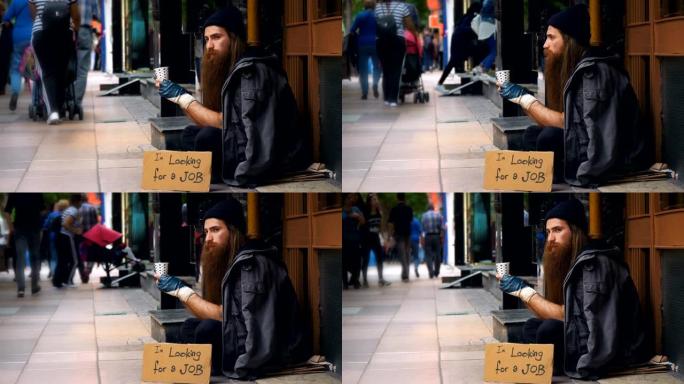 无家可归的人带着 “我在找工作” 的纸板，在拥挤的街道上乞讨
