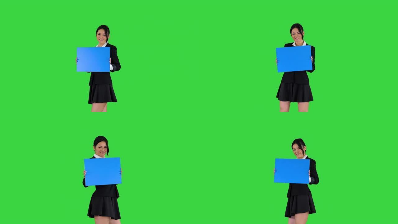 可爱的女孩拿着空木板在绿色屏幕上宣布或展示一些东西，蓝色模型