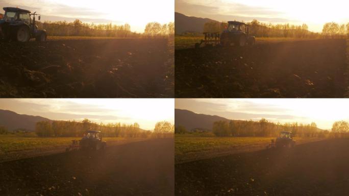在美丽的日落中，拖拉机上的农民在田间工作