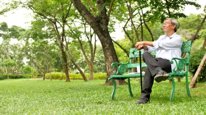 亚洲资深男子手持拐杖坐公园长椅