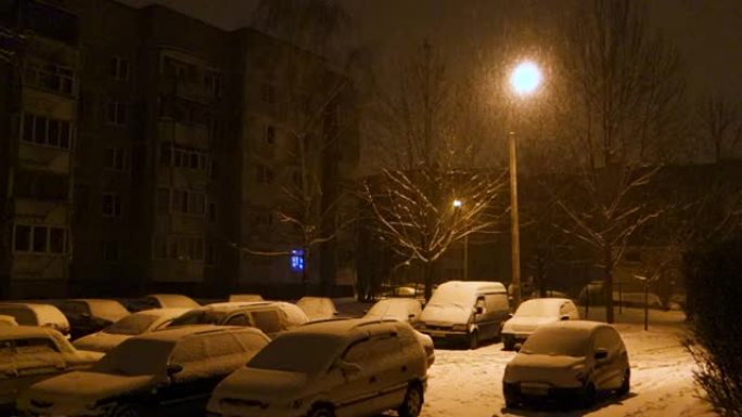 雪覆盖了晚上留在停车场的汽车
