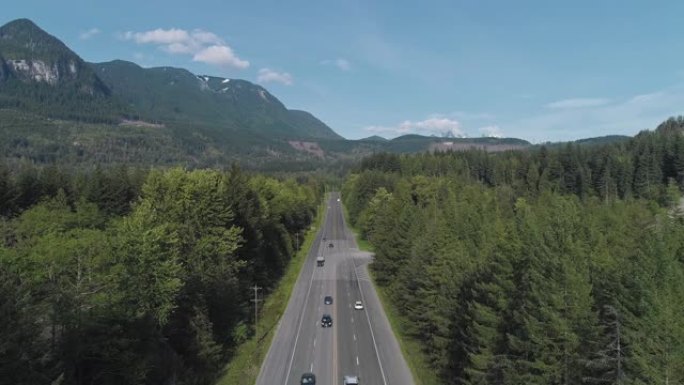 华盛顿州金条附近山区之间森林中繁忙的2号高速公路的鸟瞰图。静态摄像机的无人机视频。