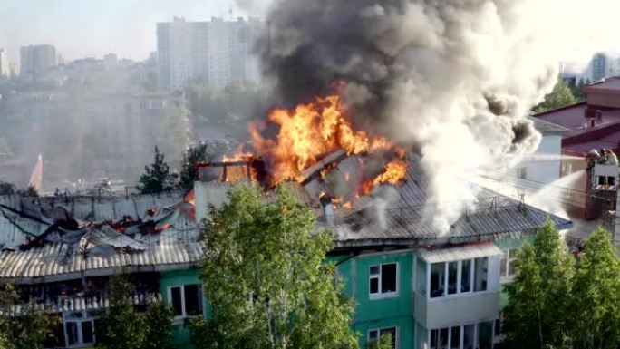一栋住宅高层建筑的屋顶燃烧，大火冒出浓烟。顶视图