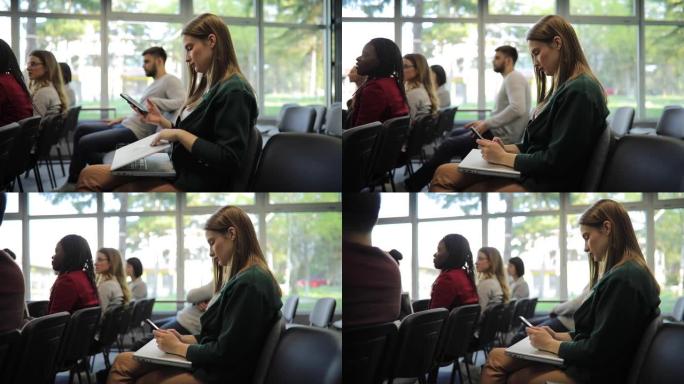 在会议上使用笔记本电脑和智能手机的女商人