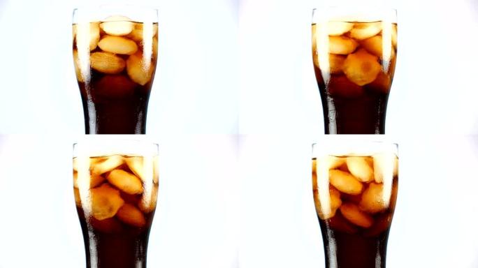 一杯可乐绕着它的轴慢慢转动。特写4k视频。白色背景。