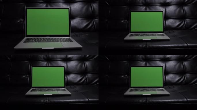 绿色屏幕沙发上白色现代笔记本的滑块拍摄