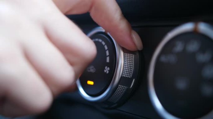 汽车空调的女人手指调谐旋钮