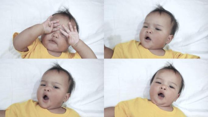 昏昏欲睡的亚洲婴儿躺在床上