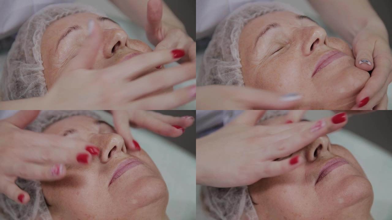 女性美容师在美容诊所对老年妇女进行面部按摩