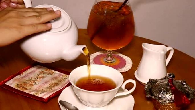 茶具: 将热茶从白锅倒入白杯-放大