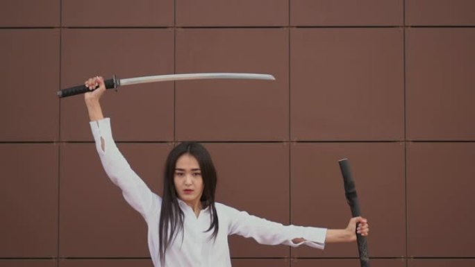 泰国美女戏剧性地从鞘中拔出剑，并迅速转向相机