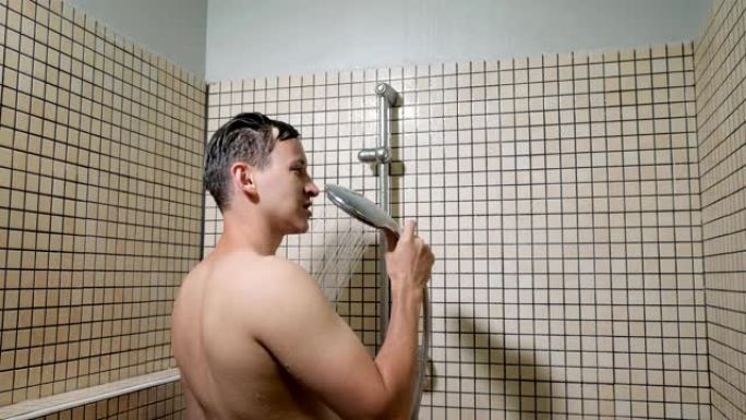 一名男子在淋浴时用淋浴器作为麦克风唱歌。