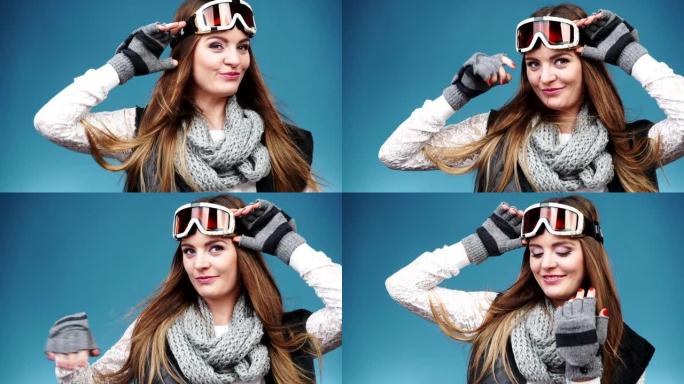 穿着暖和衣服的微笑滑雪女孩滑雪护目镜