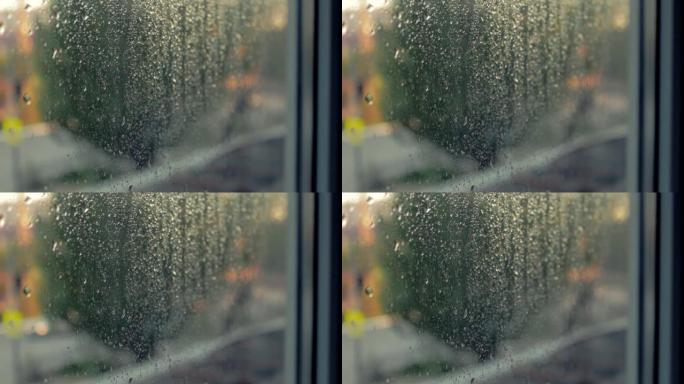 夜城的灯光。雾蒙蒙的玻璃。窗户上的液体雨滴。日落日离焦自动交通灯。悲伤和悲伤的情绪背景。