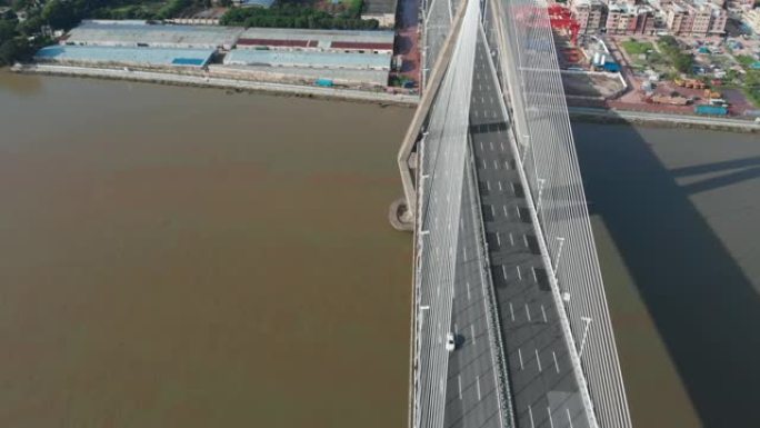 无人机在汽车行驶的大型斜拉桥周围平稳飞行。