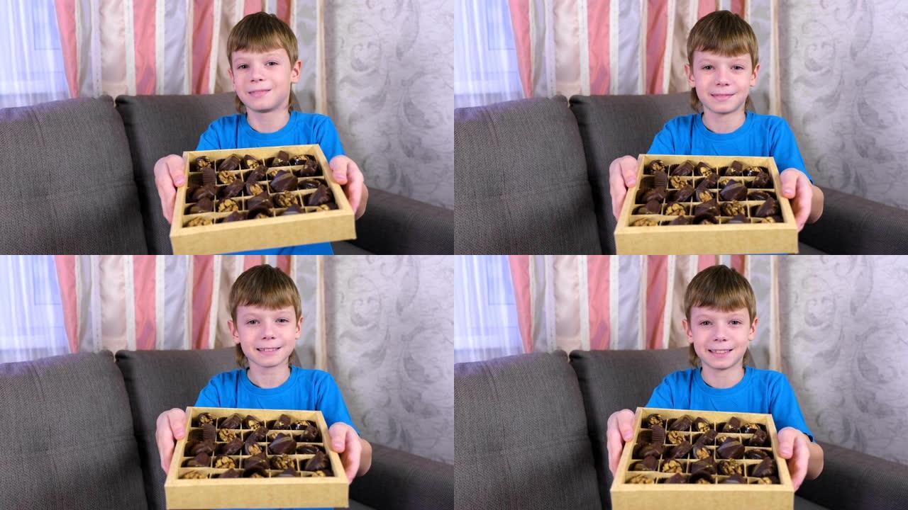 男孩在沙发上的盒子里展示巧克力。