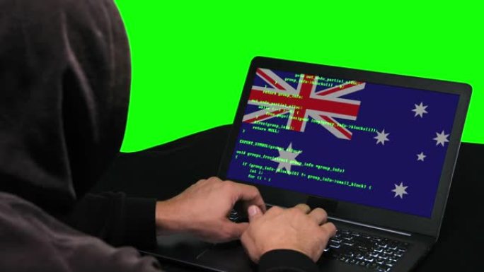 澳大利亚黑客在笔记本电脑上键入代码黑客，上面带有澳大利亚国旗，绿色屏幕背景