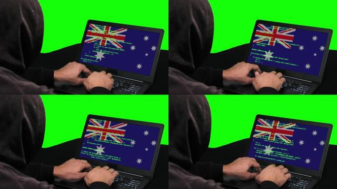 澳大利亚黑客在笔记本电脑上键入代码黑客，上面带有澳大利亚国旗，绿色屏幕背景