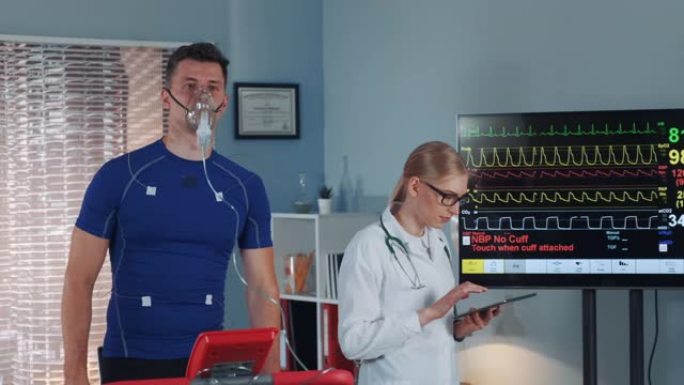 运动员戴着氧气面罩做压力测试，而心脏病专家则用平板电脑监测心电图