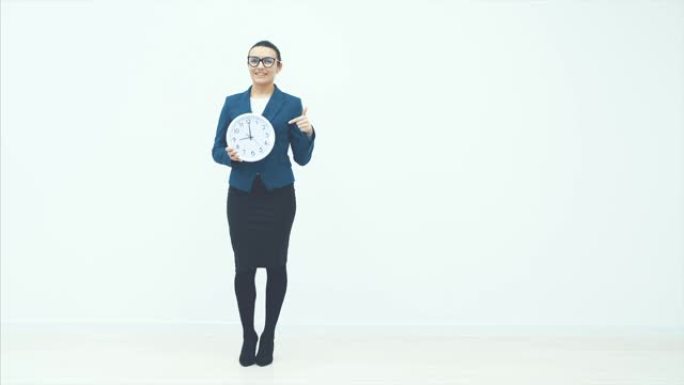 美丽的年轻女商人的肖像手握时钟，孤立在白色背景上，盘条和守时概念。复制空间。