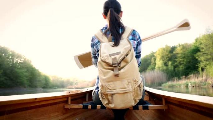 女孩划桨船的后视图