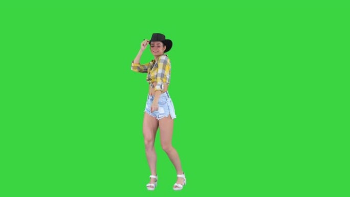 戴着牛仔帽的年轻女士在绿幕上跳舞