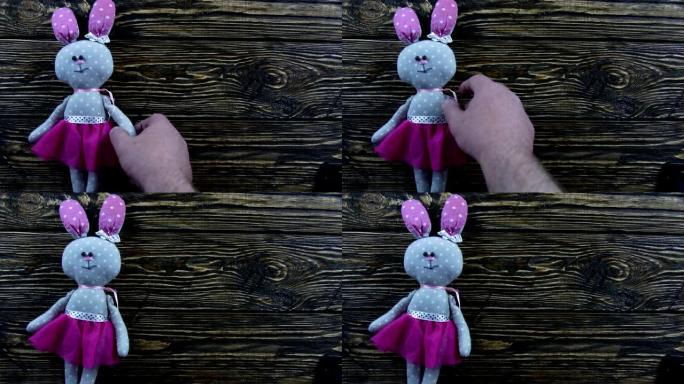木制背景上的玩具毛绒野兔