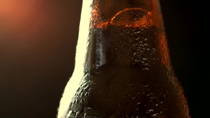 黑色背景上的一瓶冰镇啤酒的宏观旋转视频拍摄。光亮的耀斑美丽地照亮了