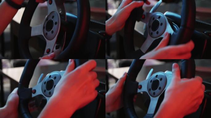一个年轻游戏玩家的手在赛车模拟器的方向盘和按钮后面的特写镜头。年轻的玩家喜欢带轮子的赛车视频游戏。计