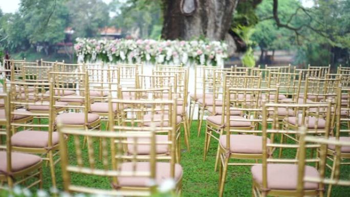 多莉女士在花园里举行的户外婚礼上，将一排椅子留给客人。