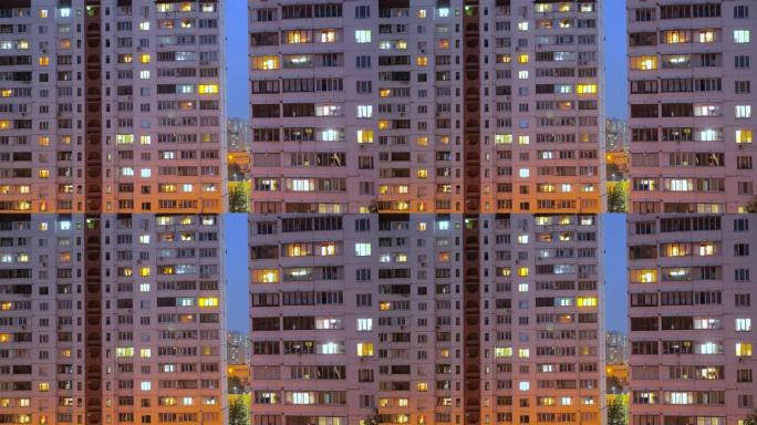 夜间照明建筑窗户的夜间时间流逝，人们住在带阳台的公寓里。用电概念。从下面看。晚上的城市街道