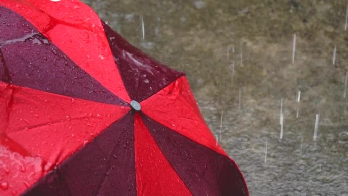 红色雨伞上的雨滴。